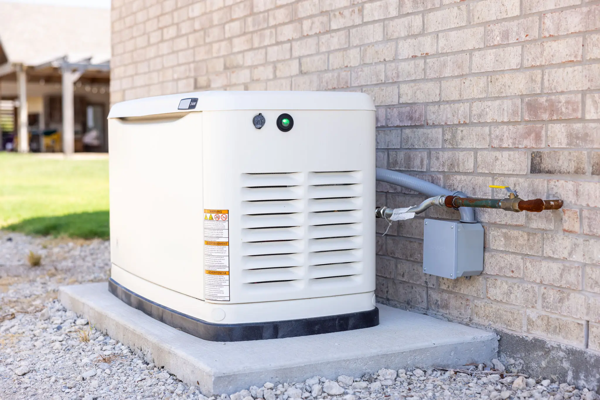 A standby generator installed outside a brick building.