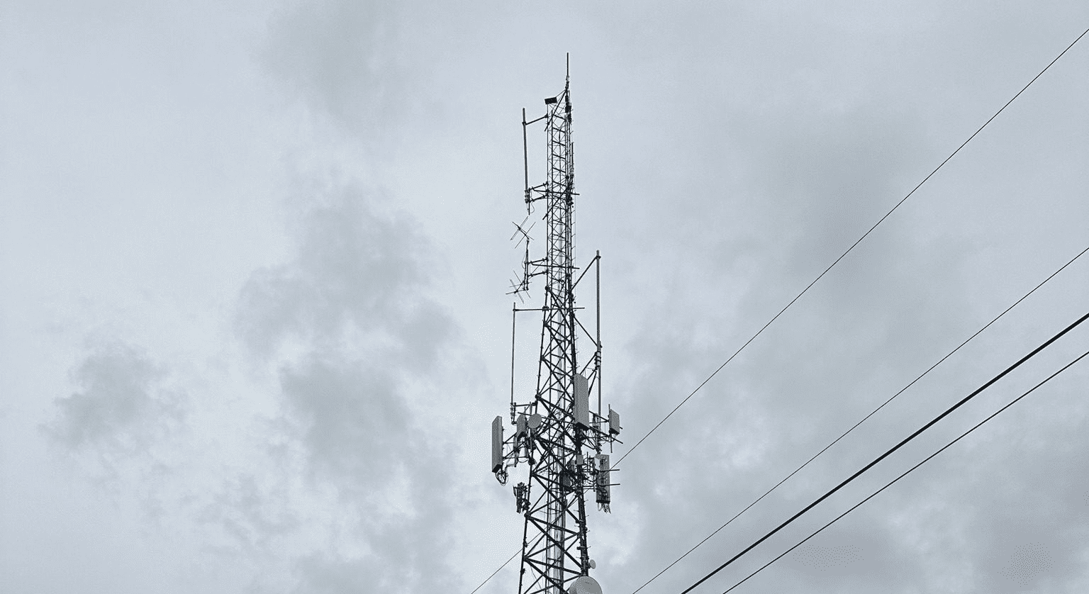 Tall communication tower against a cloudy sky.