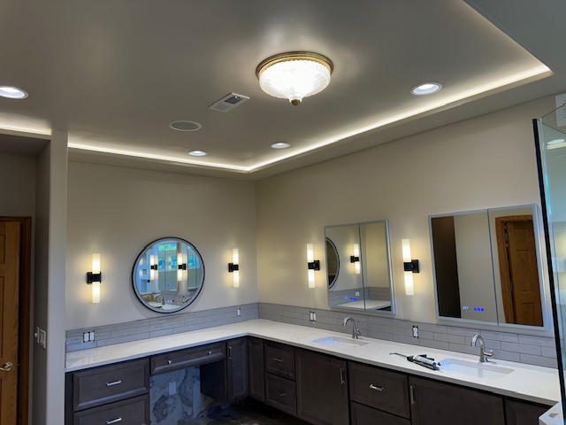 Modern bathroom vanity with circular window and elegant lighting.